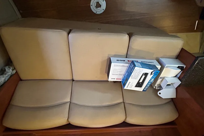 Slide: The Image of Interior of 2013 Rinker 310 Express Cruiser with beige seating and electronic boxes. - 13