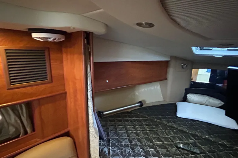 Slide: The Image of Interior cabin of 2013 Rinker 310 Express Cruiser with bed and wood paneling. - 15