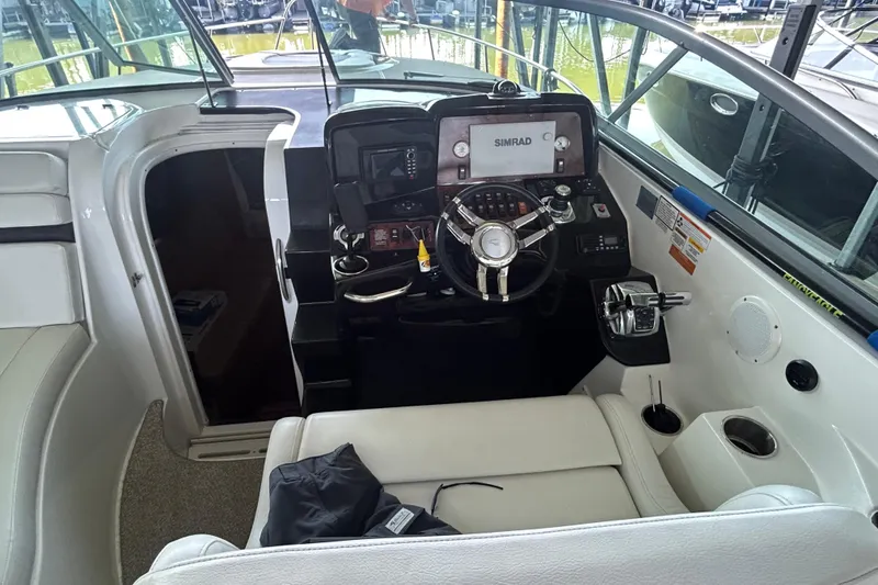 Slide: The Image of 2013 Rinker 310 Express Cruiser cockpit with steering wheel and navigation equipment. - 20