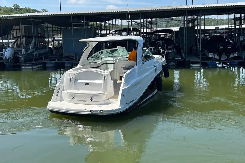 Slide: The Image of 2013 Rinker 310 Express Cruiser docked in a marina, rear view. - 34