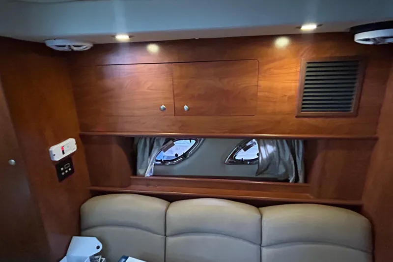 Slide: The Image of Interior of 2013 Rinker 310 Express Cruiser with wood cabinetry and porthole windows. - 40