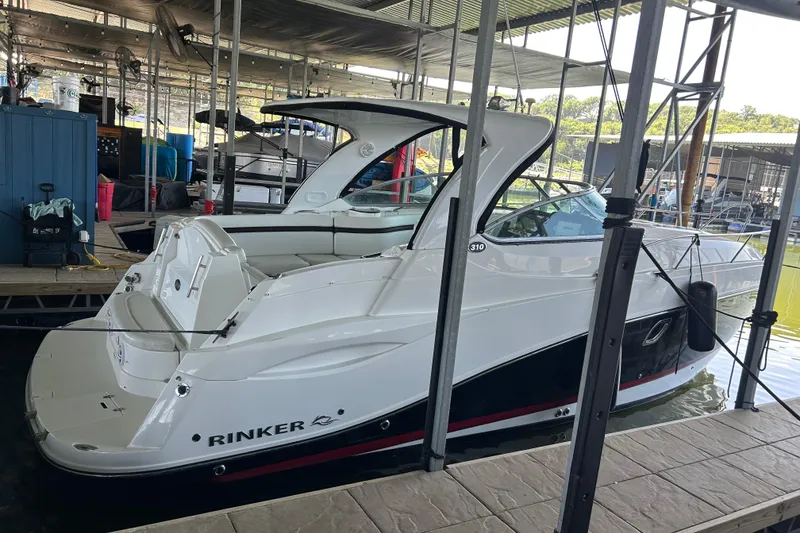 Slide: The Image of 2013 Rinker 310 Express Cruiser docked in a marina, side view. - 45