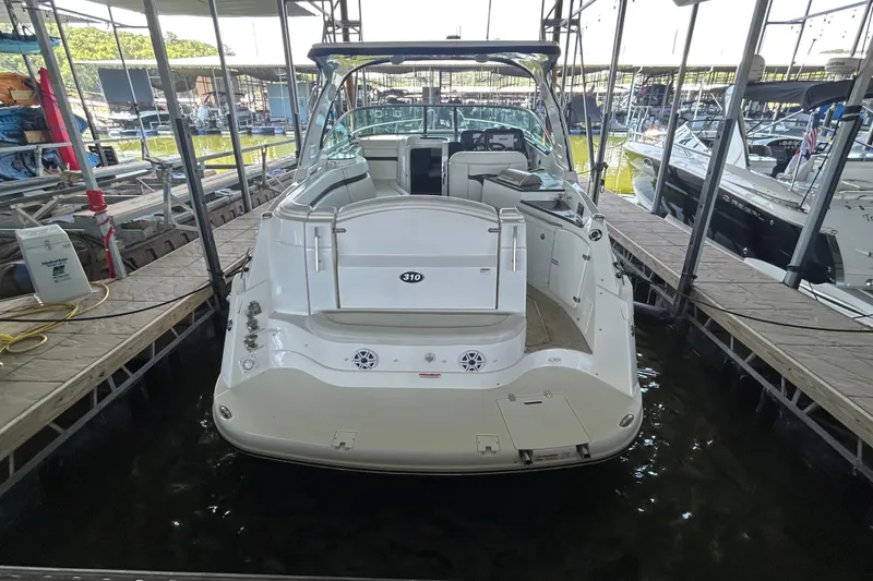 Slide: The Image of 2013 Rinker 310 Express Cruiser docked in a marina, rear view. - 46