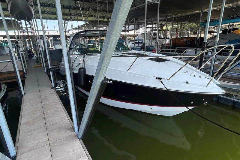 Slide: The Image of 2013 Rinker 310 Express Cruiser docked in a covered marina. - 50