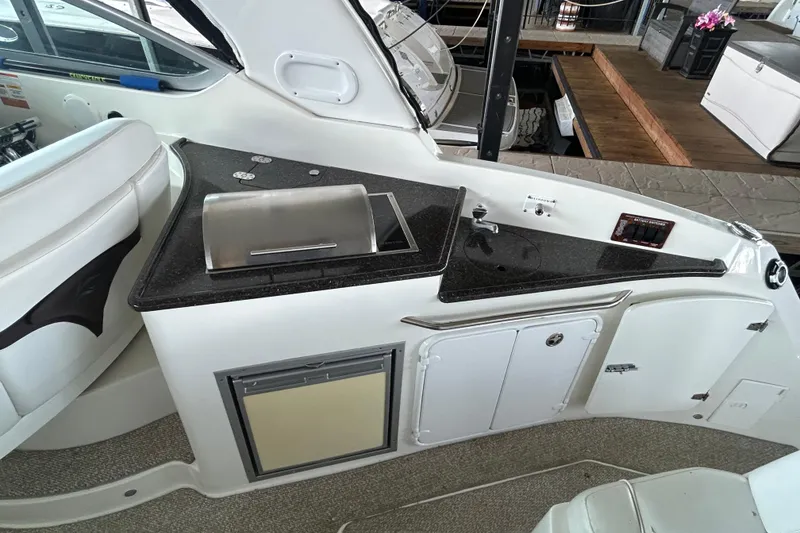 Slide: The Image of 2013 Rinker 310 Express Cruiser interior with kitchenette and seating area. - 51