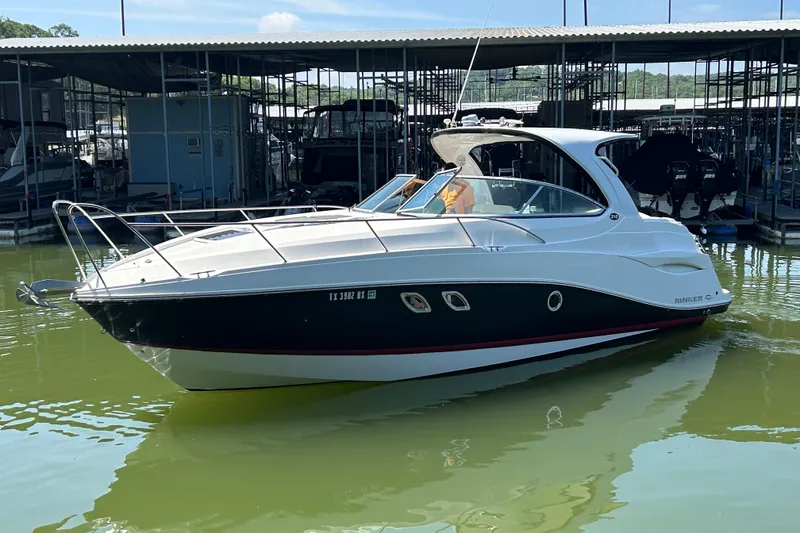Slide: The Image of 2013 Rinker 310 Express Cruiser docked in marina, sleek design, calm water. - 60