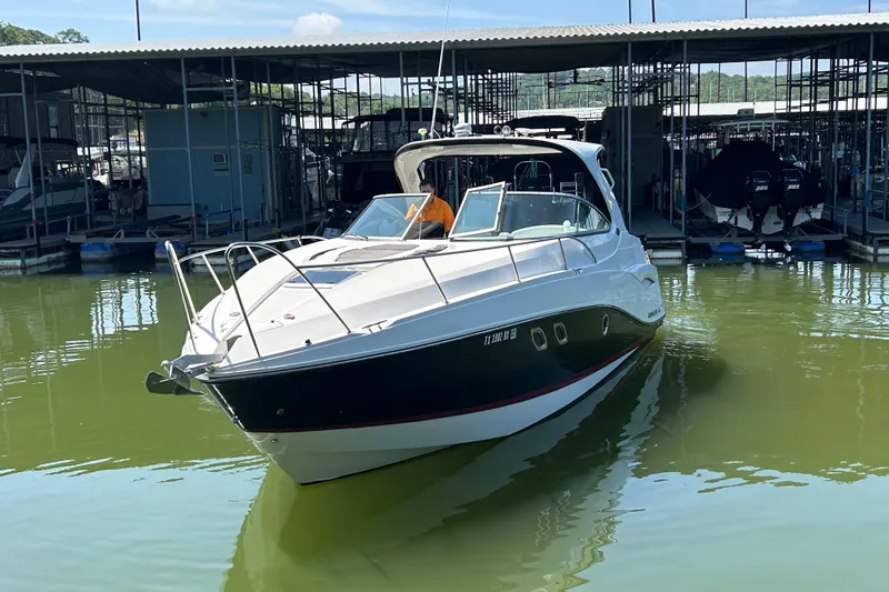 Slide: The Image of 2013 Rinker 310 Express Cruiser docked in marina, front view. - 62