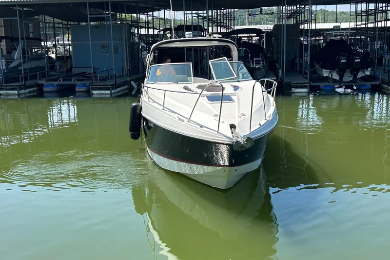 Slide: The Image of 2013 Rinker 310 Express Cruiser docked in a marina, front view. - 64