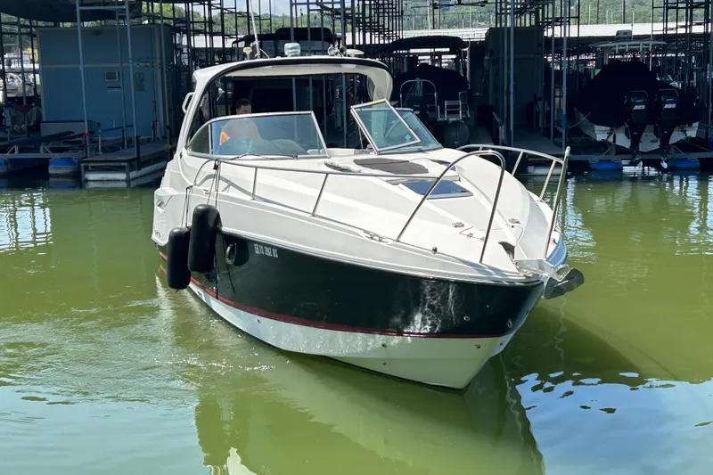Slide: The Image of 2013 Rinker 310 Express Cruiser docked in a marina, front view. - 65