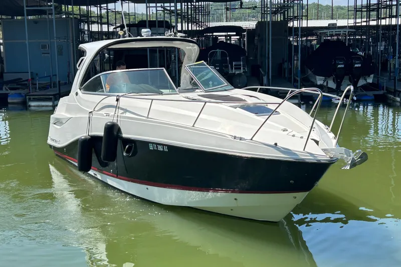 Slide: The Image of 2013 Rinker 310 Express Cruiser docked in a marina, featuring sleek design and modern amenities. - 66
