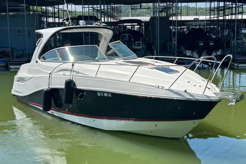Slide: The Image of 2013 Rinker 310 Express Cruiser docked in a marina, side view. - 67