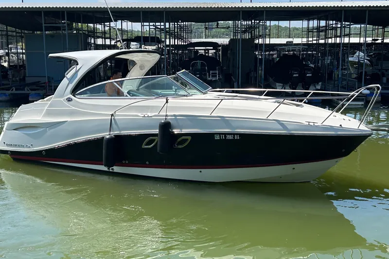 Slide: The Image of 2013 Rinker 310 Express Cruiser docked in a marina, side view. - 68