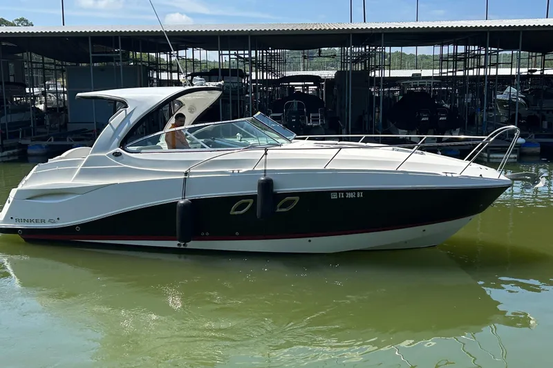 Slide: The Image of 2013 Rinker 310 Express Cruiser docked in a marina, side view. - 69
