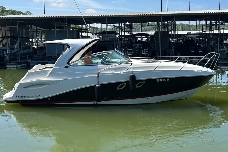 Slide: The Image of 2013 Rinker 310 Express Cruiser docked in a marina, side view. - 70