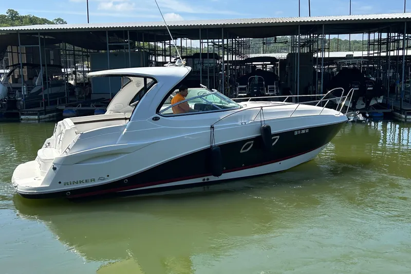 Slide: The Image of 2013 Rinker 310 Express Cruiser docked in a marina, side view. - 71