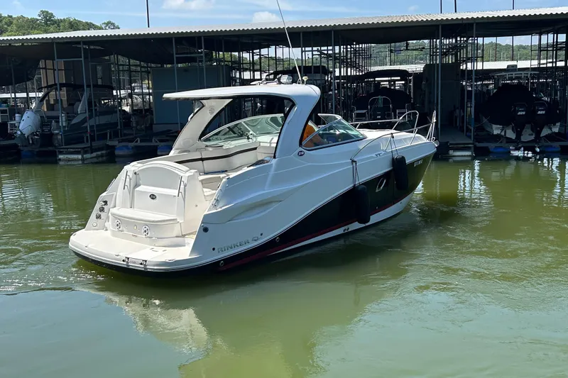 Slide: The Image of 2013 Rinker 310 Express Cruiser docked in marina, rear view. - 72