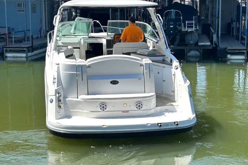 Slide: The Image of 2013 Rinker 310 Express Cruiser docked in marina, rear view. - 74