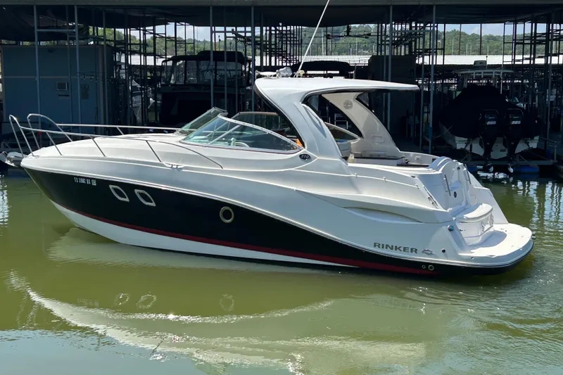 Slide: The Image of 2013 Rinker 310 Express Cruiser docked in a marina, showcasing sleek design and modern features. - 77