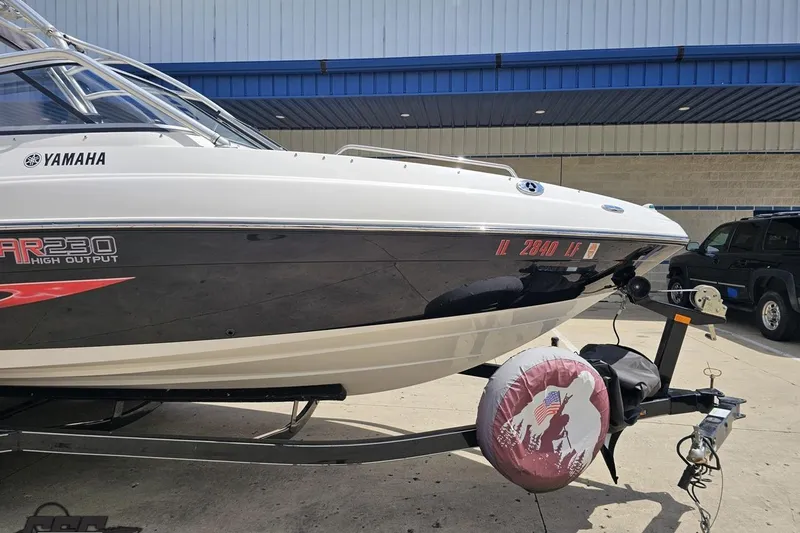 Slide: The Image of 2007 Yamaha AR230 HO boat on trailer, parked outdoors near a building. - 10