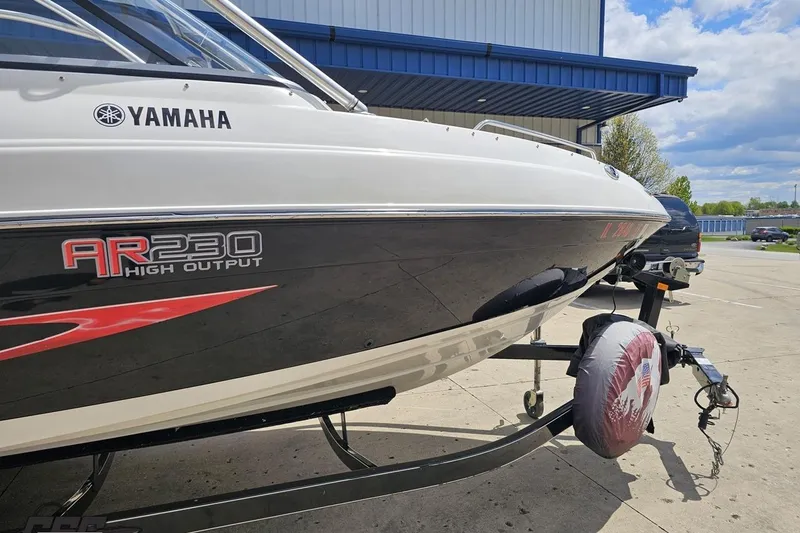 Slide: The Image of 2007 Yamaha AR230 HO boat on trailer, parked outdoors near a building. - 4