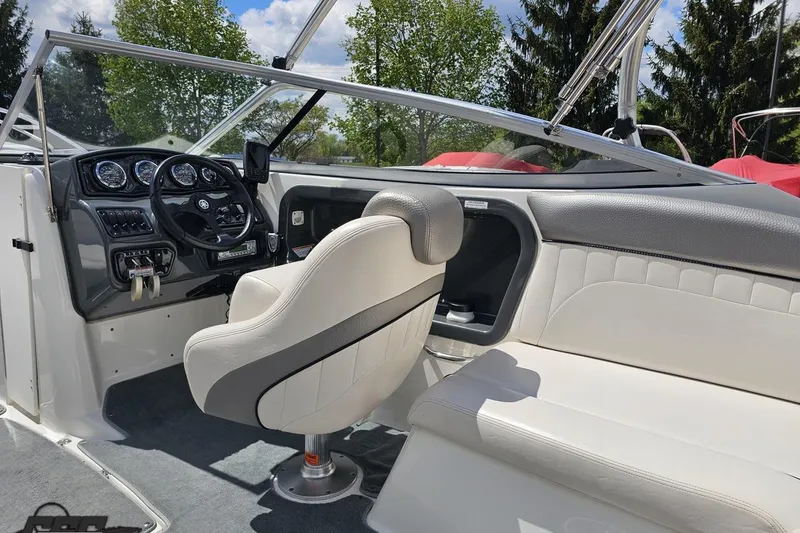 Slide: The Image of 2007 Yamaha Boats AR230 HO interior with steering wheel and seating, under clear sky. - 45