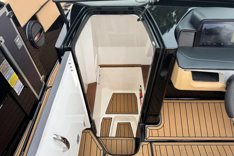 Slide: The Image of 2025 MasterCraft X26 boat interior with open cabin door, showcasing sleek design and wood flooring. - 19
