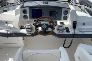 Slide: The Image of 2007 Sea Ray 36 Sedan Bridge helm with modern controls and wood-accented steering wheel. - 4