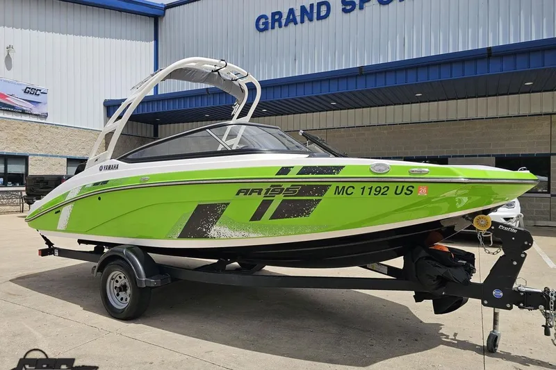Slide: The Image of 2022 Yamaha AR195 boat in vibrant green on trailer outside dealership. - 13