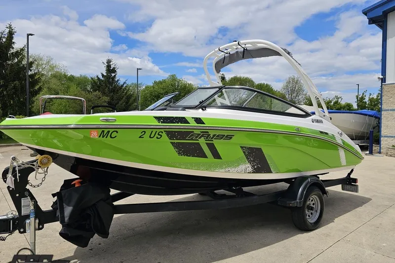 Slide: The Image of 2022 Yamaha AR195 boat in vibrant green on a trailer, outdoors. - 21