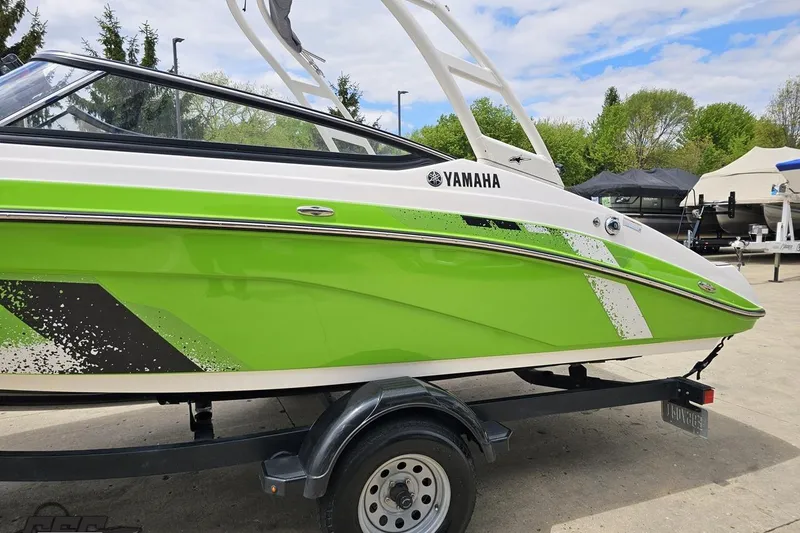 Slide: The Image of 2022 Yamaha AR195 boat in vibrant green on a trailer, outdoors. - 25