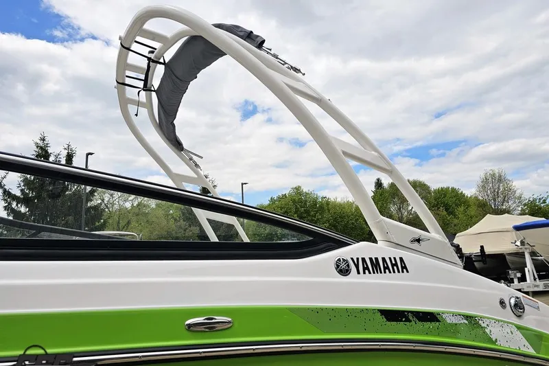 Slide: The Image of 2022 Yamaha Boats AR195 with sleek design and vibrant green accents under a cloudy sky. - 27