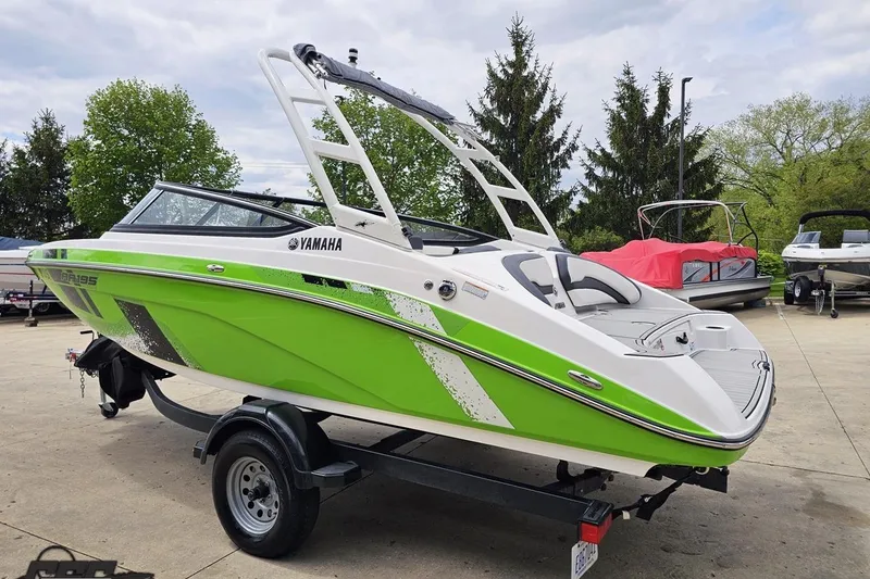 Slide: The Image of 2022 Yamaha Boats AR195 in vibrant green on a trailer, parked outdoors. - 29
