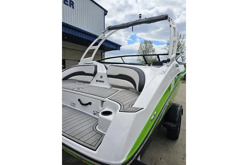 Slide: The Image of 2022 Yamaha Boats AR195 with sleek design and green accents, docked outdoors. - 34