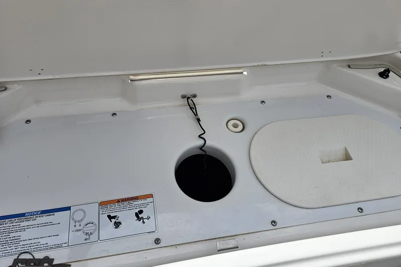 Slide: The Image of 2022 Yamaha AR195 boat storage compartment with safety warnings and access panel. - 37