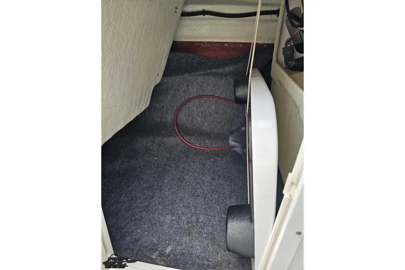 Slide: The Image of Interior storage compartment of 2022 Yamaha Boats AR195, featuring carpeted flooring and equipment. - 52