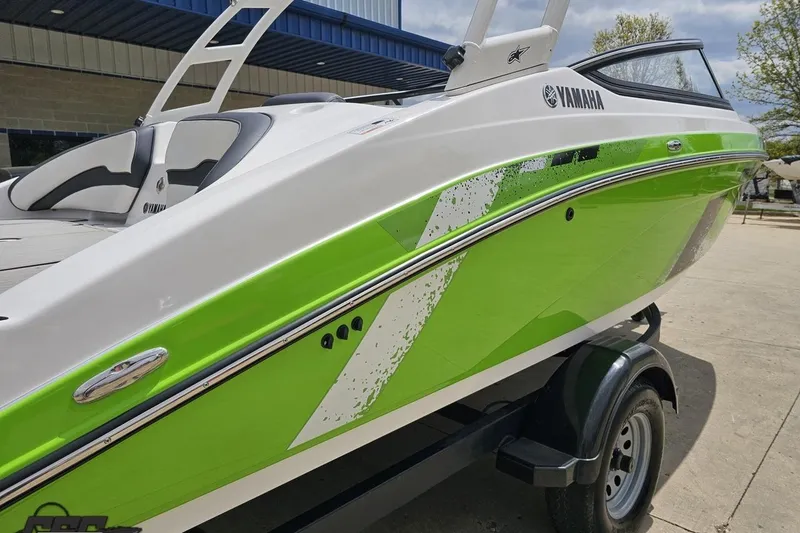Slide: The Image of 2022 Yamaha Boats AR195 with vibrant green and white design on a trailer. - 9