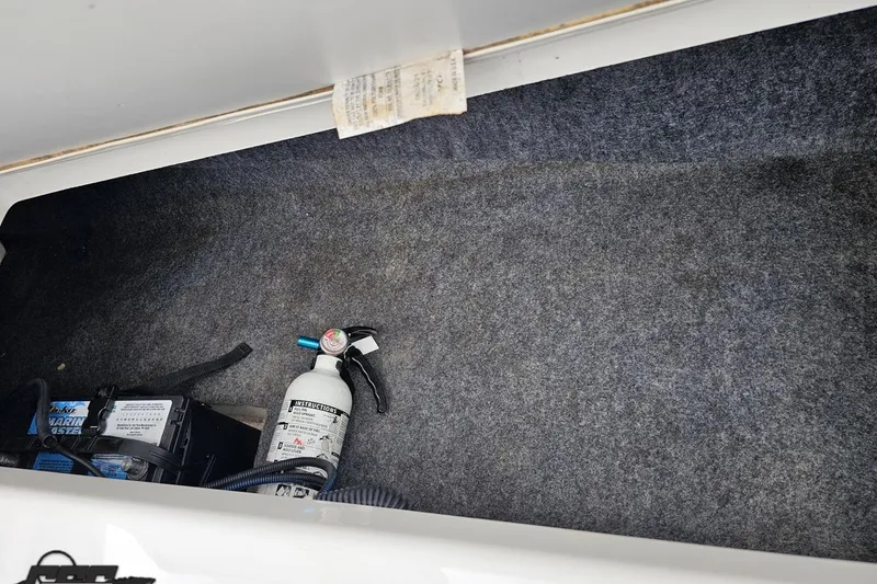 Slide: The Image of Storage compartment of 2022 Yamaha AR195 boat with fire extinguisher and battery. - 91