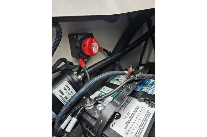 Slide: The Image of 2022 Yamaha AR195 boat battery compartment with wiring and switch. - 92