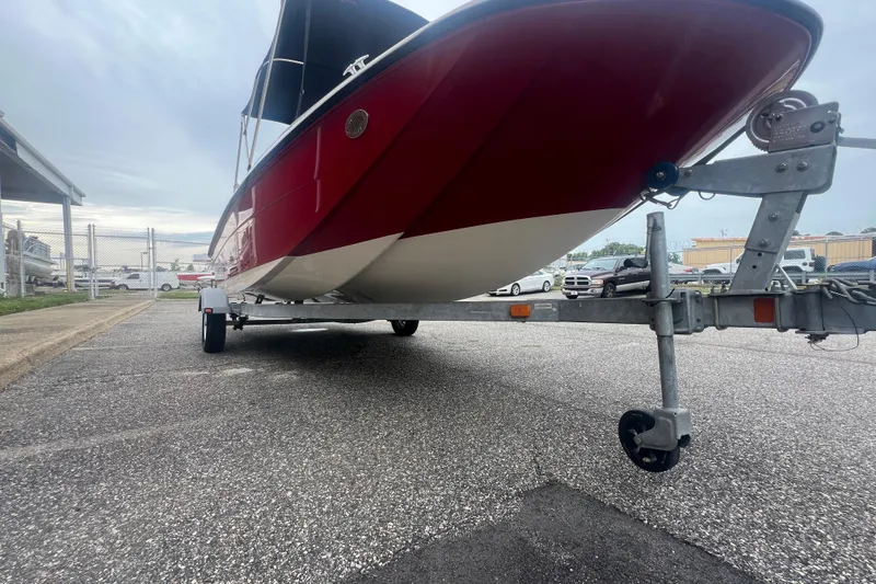 Slide: The Image of 2015 Bayliner Element XL boat on trailer, red hull, parked outdoors. - 11