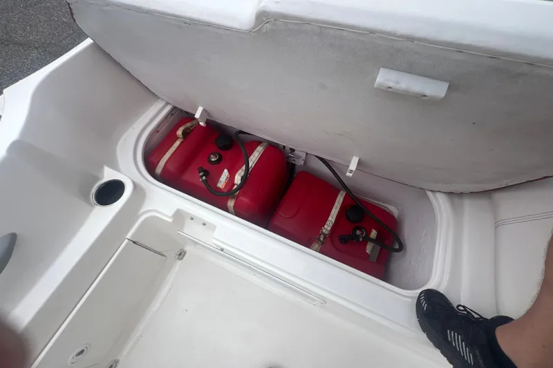 Slide: The Image of Open storage compartment on 2015 Bayliner Element XL boat with red fuel tanks inside. - 22