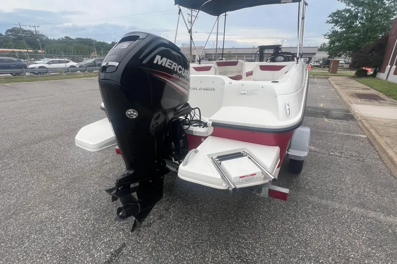 Slide: The Image of 2015 Bayliner Element XL boat with Mercury outboard motor, parked on pavement. - 5