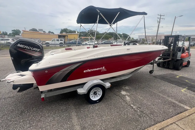Slide: The Image of 2015 Bayliner Element XL boat with Mercury engine on trailer, parked outdoors. - 7