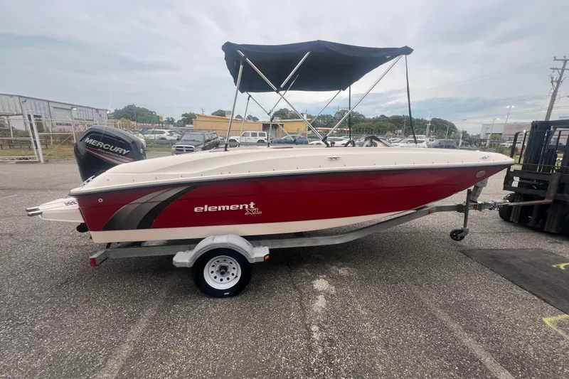 Slide: The Image of 2015 Bayliner Element XL boat with red hull and black canopy on trailer. - 8