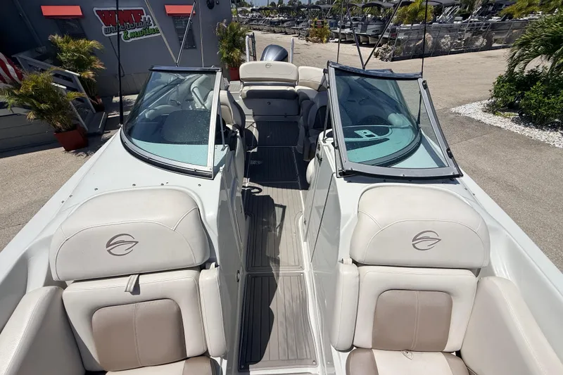 Slide: The Image of 2018 Crownline Eclipse E26 XS boat interior with white seating and dual windshields. - 16