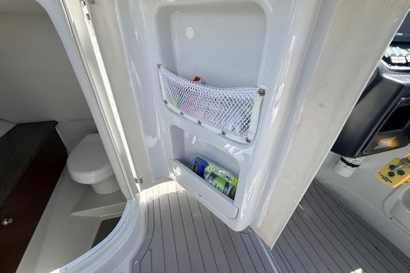 Slide: The Image of Interior of 2018 Crownline Eclipse E26 XS boat showing storage and toilet area. - 21