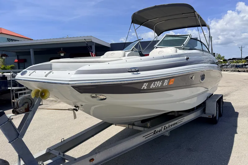 Slide: The Image of 2018 Crownline Eclipse E26 XS boat on trailer, parked outdoors under clear sky. - 3