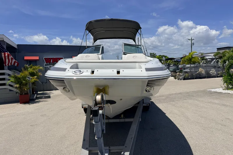 Slide: The Image of 2018 Crownline Eclipse E26 XS boat on trailer under clear blue sky. - 4