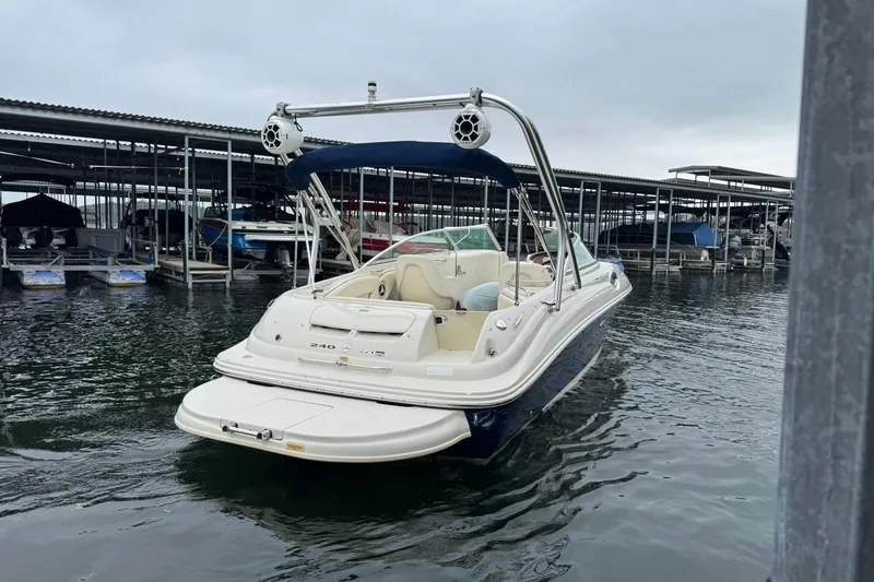 Slide: The Image of 2008 Sea Ray 240 Sundeck boat docked at marina under cloudy sky. - 10