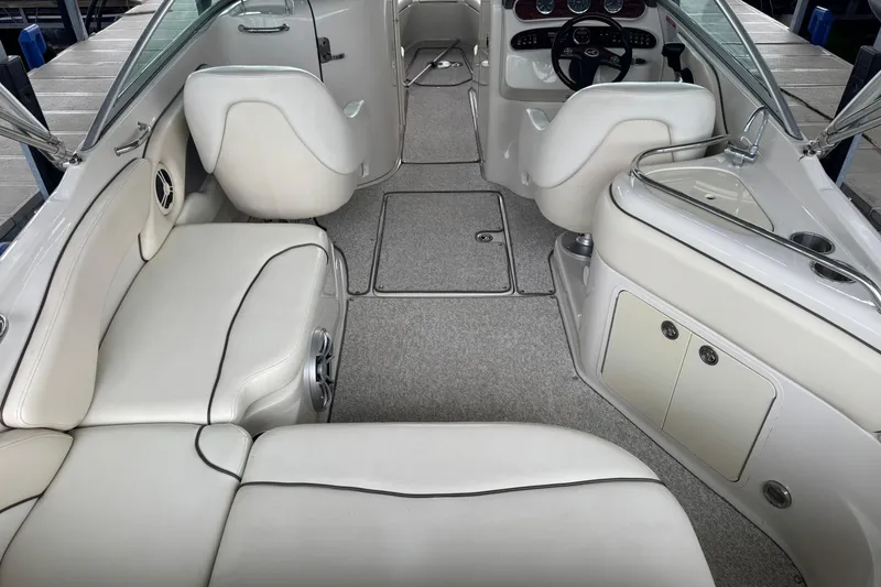 Slide: The Image of 2008 Sea Ray 240 Sundeck interior with white seating and modern dashboard. - 11