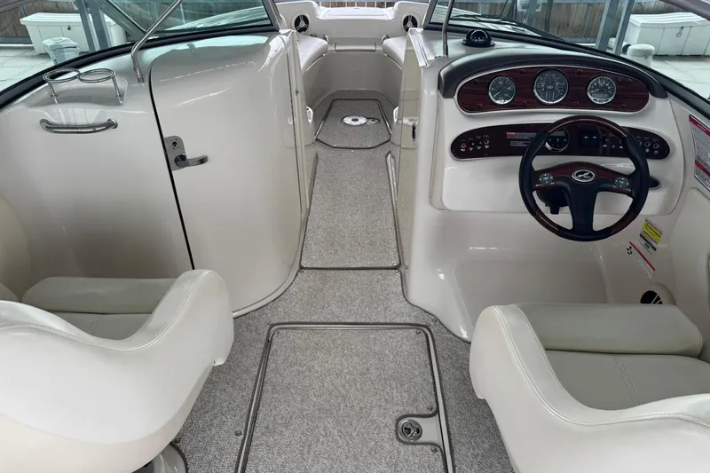 Slide: The Image of 2008 Sea Ray 240 Sundeck interior with steering wheel, gauges, and seating. - 12